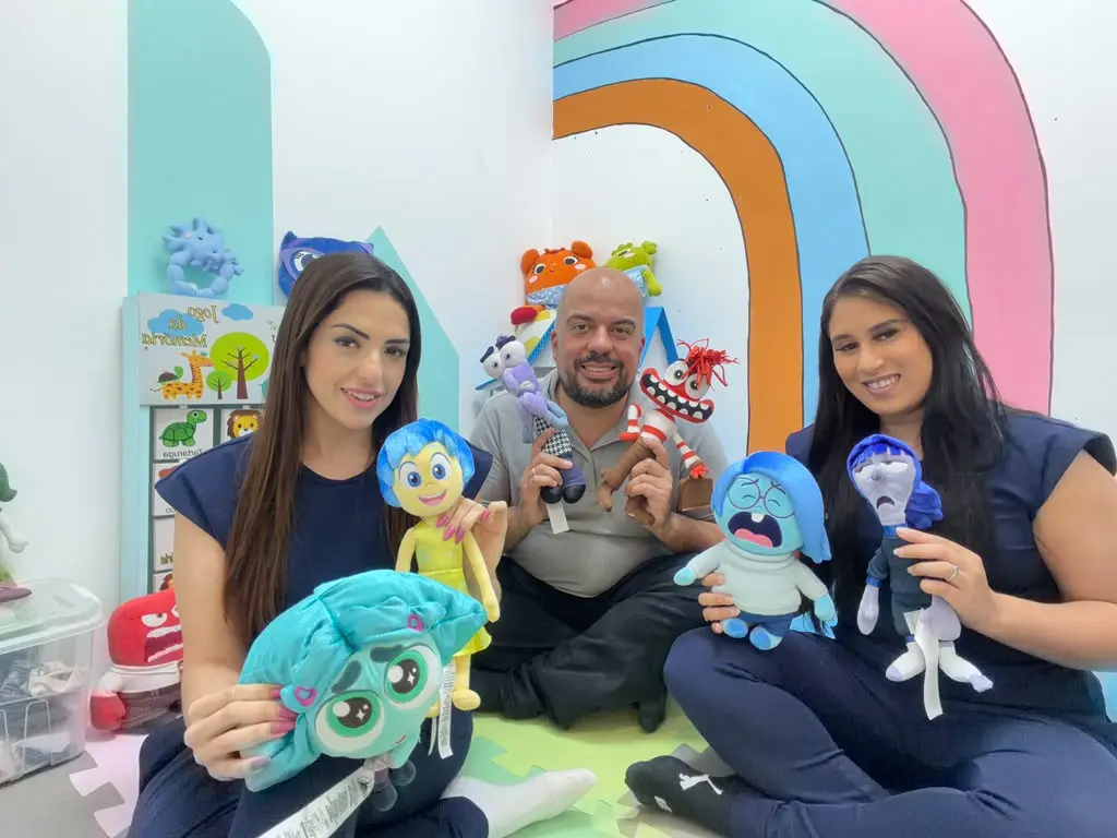 Equipe de psicologia infantil da Clínica Psi na sala de ludoterapia, com os personagens de Divertida Mente