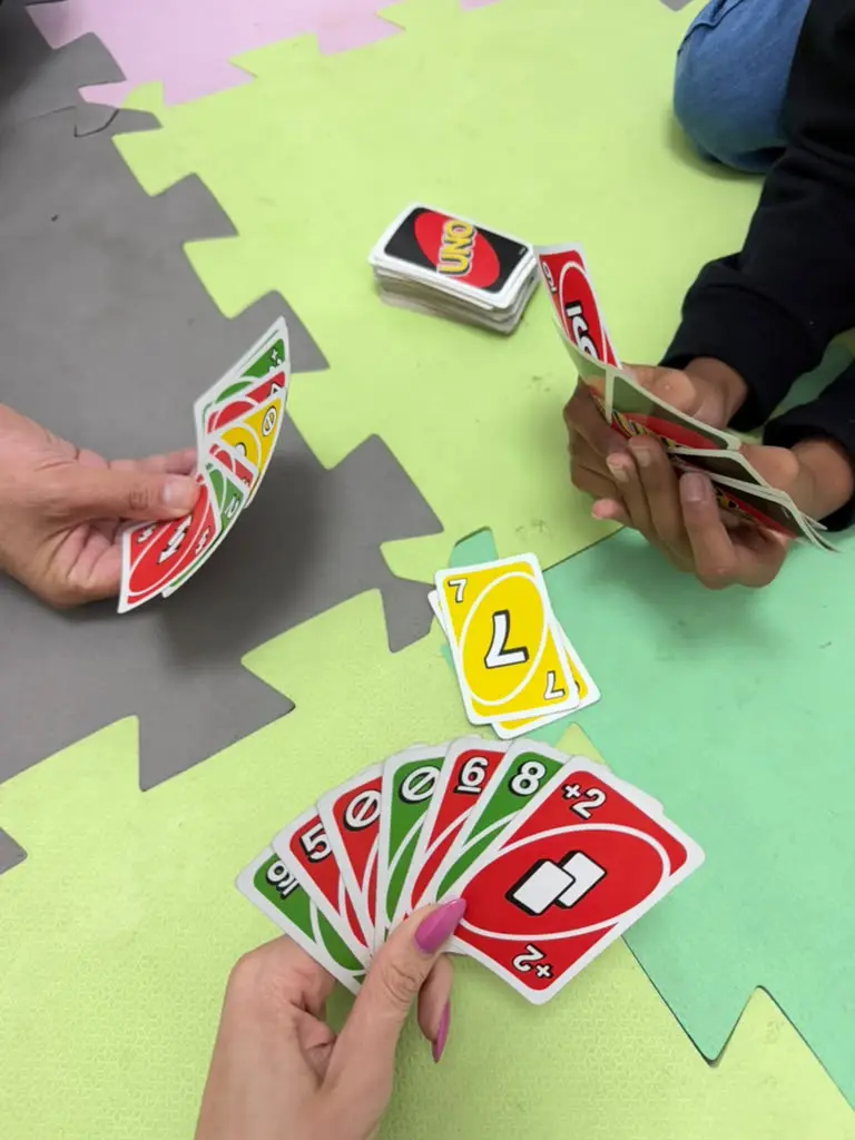 Partida de UNO no tatame da sala infantil da Clínica Psi durante a ludoterapia