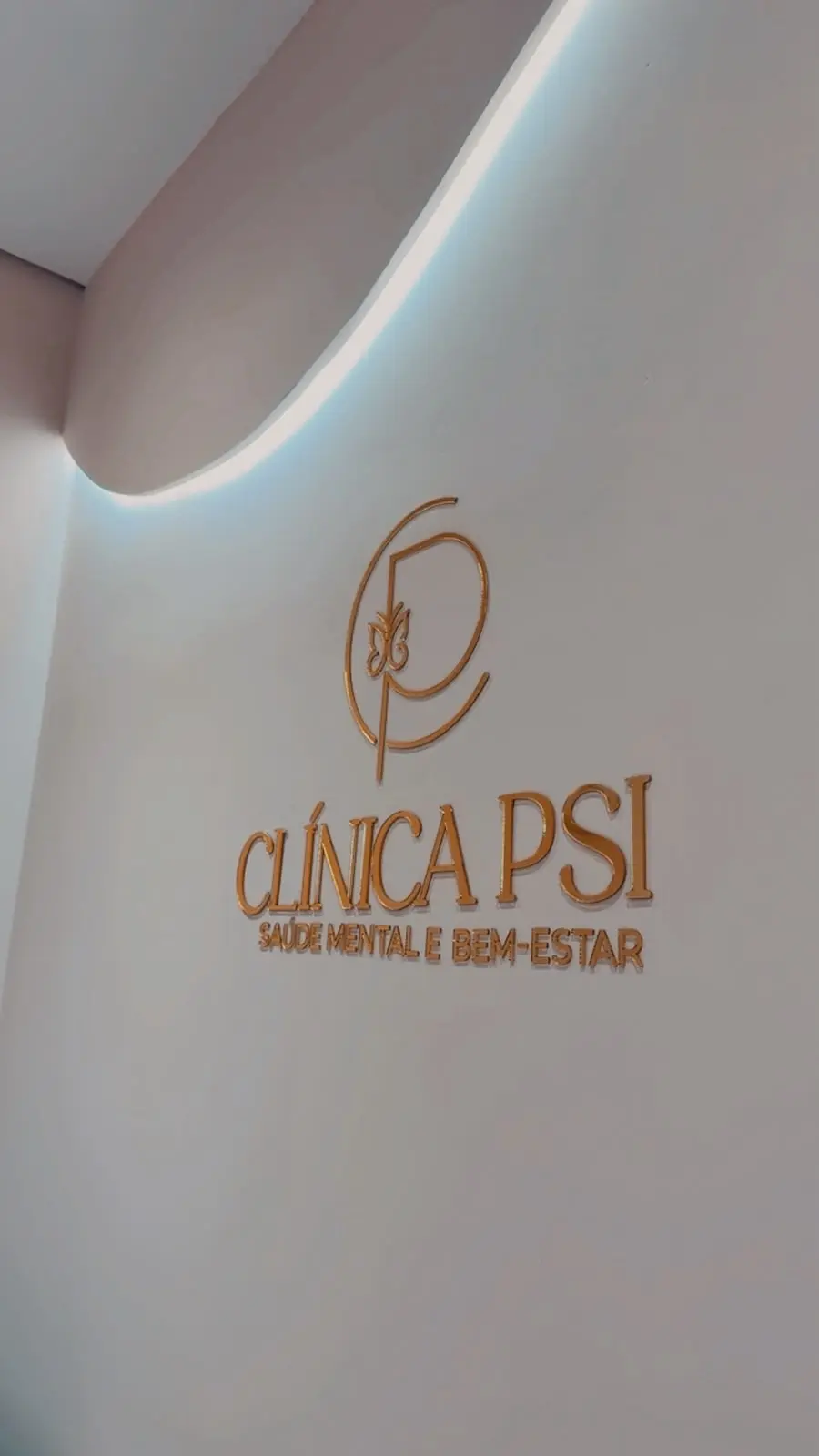Logo dourada da Clínica Psi na parede da recepção