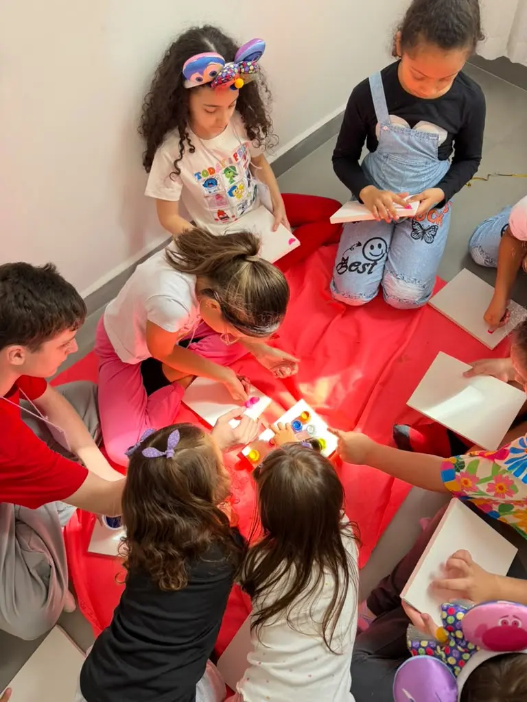 Crianças pintando juntas em uma oficina na Clínica Psi