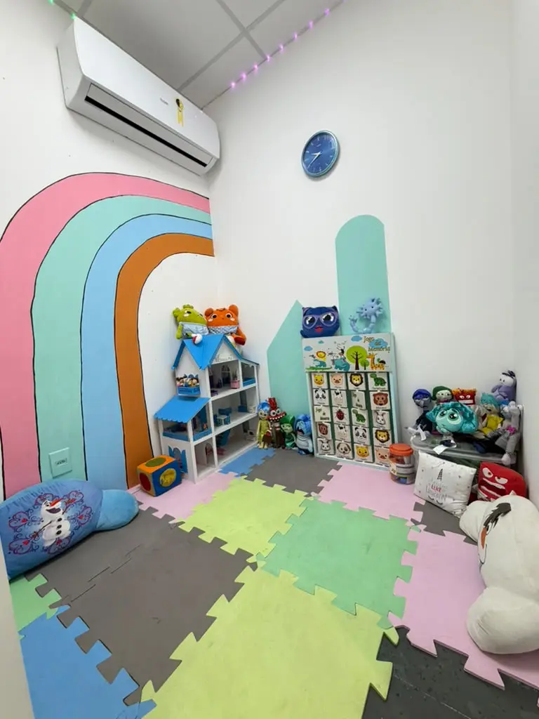 Sala infantil da Clínica Psi, com arco-íris na parede e brinquedos